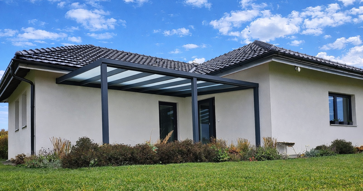 Hliníková pergola se skleněným zastřešením u rodinného domu